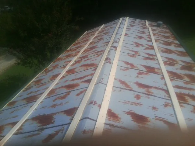 Rusted metal roof panels with new wood purlins before replacement — Storm Damage Roof Repair in Ipswich by Roofing Brothers